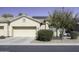 House exterior featuring a tan facade, two-car garage, and mature trees at 1548 E Melrose Dr, Casa Grande, AZ 85122