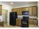 Kitchen boasting wood cabinets, black appliances, and ample counter space at 1548 E Melrose Dr, Casa Grande, AZ 85122