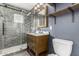 Modern bathroom featuring a glass-enclosed shower, wooden vanity, and open shelving at 1934 E Brill St, Phoenix, AZ 85006