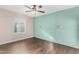 Bedroom with hardwood floors, a ceiling fan, a mint accent wall, and a window letting in natural light at 1934 E Brill St, Phoenix, AZ 85006