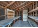 Unfinished storage room with wood framing, concrete floor, shelving, and a wood door at 1934 E Brill St, Phoenix, AZ 85006