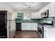 Modern kitchen featuring stainless steel appliances, white cabinets, and green backsplash at 1934 E Brill St, Phoenix, AZ 85006