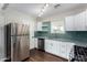 Updated kitchen features stainless steel appliances, white cabinets, and green backsplash at 1934 E Brill St, Phoenix, AZ 85006