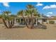 Landscaped backyard with gravel, patio cover, and palm trees at 19611 N Stardust Blvd, Sun City West, AZ 85375