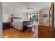 Bright bedroom with a sleigh bed, wood floors, and large window at 19611 N Stardust Blvd, Sun City West, AZ 85375