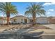 Single-story home with a landscaped front yard, two palm trees, and a two-car garage at 19611 N Stardust Blvd, Sun City West, AZ 85375