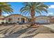 Single-story home with a landscaped front yard, two palm trees, and a two-car garage at 19611 N Stardust Blvd, Sun City West, AZ 85375