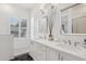 Sunlit bathroom with a double sink vanity, white cabinetry, and plantation shutters at 20490 N 78Th Way, Scottsdale, AZ 85255