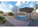 Backyard hot tub area with patio umbrella and landscaping at 21004 E Sunset Dr, Queen Creek, AZ 85142