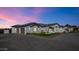 Stunning exterior view of home with lush landscaping, stone driveway, and beautiful contemporary architecture at sunset at 24540 S 190Th Ct, Queen Creek, AZ 85142