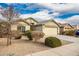 Tan house with a two-car garage and landscaped yard at 25740 W Watkins St, Buckeye, AZ 85326