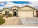 Tan house with a two-car garage and landscaped yard at 25740 W Watkins St, Buckeye, AZ 85326