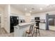 Modern kitchen with white cabinets, black appliances, and an island with seating at 25740 W Watkins St, Buckeye, AZ 85326