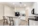 Modern kitchen with white cabinets, black appliances, and an island with seating at 25740 W Watkins St, Buckeye, AZ 85326