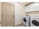 Bright laundry room with cabinets and full-size washer and dryer at 25740 W Watkins St, Buckeye, AZ 85326