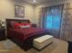 Cozy bedroom with king-size bed, red and black bedding, and window with blinds at 26019 W Ponderosa Ln, Buckeye, AZ 85396