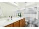 Clean bathroom with wood cabinets, striped shower curtain, and updated fixtures at 28125 N Silver Ln, San Tan Valley, AZ 85143