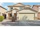 Two-story house with a beige exterior, two-car garage, and landscaped front yard at 28125 N Silver Ln, San Tan Valley, AZ 85143