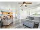 Open concept living room with kitchen views, gray sectional sofa, and wood-look floors at 28125 N Silver Ln, San Tan Valley, AZ 85143