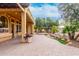 A covered patio extends to a stone-paved backyard featuring a beautiful waterfall and lush landscaping at 28247 N 128Th Dr, Peoria, AZ 85383