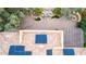 Aerial view of backyard featuring desert landscaping, a water feature, stone seating area, and solar panels at 28247 N 128Th Dr, Peoria, AZ 85383