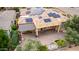 Aerial view of backyard with large covered patio, pavers, pond, and efficient solar panel array at 28247 N 128Th Dr, Peoria, AZ 85383