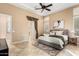 Well-lit bedroom features tile floors, shutters, a ceiling fan, and an open doorway at 28247 N 128Th Dr, Peoria, AZ 85383