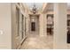 Elegant hallway with tiled floors, decorative lighting and views into the kitchen and living spaces at 28247 N 128Th Dr, Peoria, AZ 85383