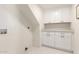 Laundry room with white cabinets and hexagon tile floor at 3258 E Dover St, Mesa, AZ 85213