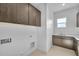 Clean laundry room with modern wood cabinets at 34045 N Borgata Trl, Queen Creek, AZ 85144