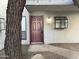 Exterior view of condo building, showcasing a burgundy front door with a walkway at 3405 W Danbury Dr # D121, Phoenix, AZ 85053