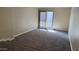 Living area with grey carpet and access to patio at 3405 W Danbury Dr # D121, Phoenix, AZ 85053