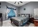 Bright bedroom with a ceiling fan, striped bedding, and teal curtains at 3923 W Hayduk Rd, Laveen, AZ 85339