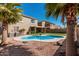 Backyard with a sparkling pool, covered patio, artificial turf, and low-maintenance desert landscaping at 42531 W Chisholm Dr, Maricopa, AZ 85138