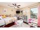 Bright bedroom with hardwood floors, ceiling fan, pink accents, and natural light from a large window at 42531 W Chisholm Dr, Maricopa, AZ 85138