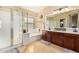 Well-lit main bathroom with soaking tub, shower, double sinks, and stylish fixtures at 42531 W Chisholm Dr, Maricopa, AZ 85138