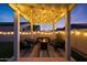 Backyard patio has a pergola with string lights and modern seating arranged around a cozy firepit at 4752 S Orbit Ave, Mesa, AZ 85212