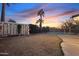 Fenced pool and tropical landscaping enhance this backyard with storage shed at dusk at 5045 W Mescal St, Glendale, AZ 85304