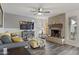 Cozy living room featuring a brick fireplace, ceiling fan, and comfortable seating with gray and white accents at 5045 W Mescal St, Glendale, AZ 85304