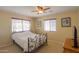 Bedroom featuring a metal frame bed, ceiling fan, window with blinds, and soft yellow paint at 50530 W Mockingbird Ln, Maricopa, AZ 85139