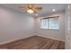 Bedroom featuring wood laminate flooring, a ceiling fan with light fixture, window with blinds, and light blue walls at 50530 W Mockingbird Ln, Maricopa, AZ 85139