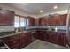 Spacious kitchen featuring stainless steel appliances, a window over the sink, and dark wood cabinets at 50530 W Mockingbird Ln, Maricopa, AZ 85139