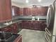 Well-lit kitchen featuring dark wood cabinets, stainless steel appliances, and decorative backsplash at 50530 W Mockingbird Ln, Maricopa, AZ 85139