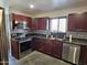 Modern kitchen featuring stainless steel appliances and dark wood cabinets at 50530 W Mockingbird Ln, Maricopa, AZ 85139