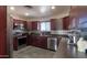 Well-lit kitchen featuring dark cabinetry, modern stainless steel appliances, and stylish backsplash at 50530 W Mockingbird Ln, Maricopa, AZ 85139