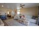 Comfortable living room with neutral decor, a ceiling fan, and a cozy seating arrangement with a wooden chest-style coffee table at 50530 W Mockingbird Ln, Maricopa, AZ 85139