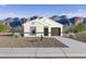 White stucco house with brown garage door and desert landscaping; mountain views at 5552 E Rock Bush Ln, San Tan Valley, AZ 85140