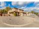 Two-story house with tan exterior, tile roof, and a long driveway at 5766 W Brown St, Glendale, AZ 85302