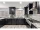 Modern kitchen with dark cabinetry, granite counters, and stainless steel appliances at 5766 W Brown St, Glendale, AZ 85302