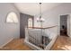 Upstairs hallway with hardwood floors and elegant chandelier at 5766 W Brown St, Glendale, AZ 85302